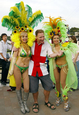A England fan poses for a photograph with Brazil supporters outside Shizuoka's stadium June 21, 2002, after Brazil beat England in a quarter-final World Cup match. Brazil won 2-1 to advance to the semi-finals.