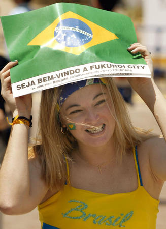 A Brazil fan shields herself from the sun as she makes her way to Shizuoka's stadium from Fukuroi June 21, 2002.